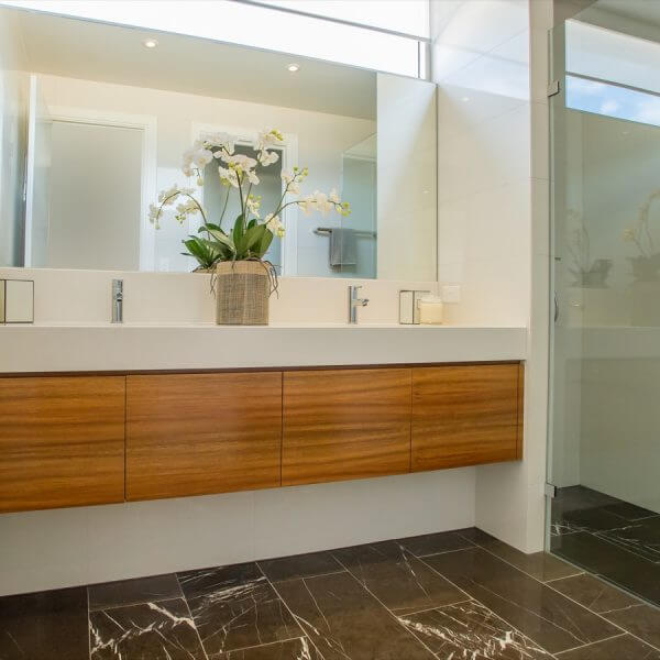 A beautiful modern bathroom. Elegant with Modern wash basins, Cream Bathroom with Marble Floor and wooden shelves