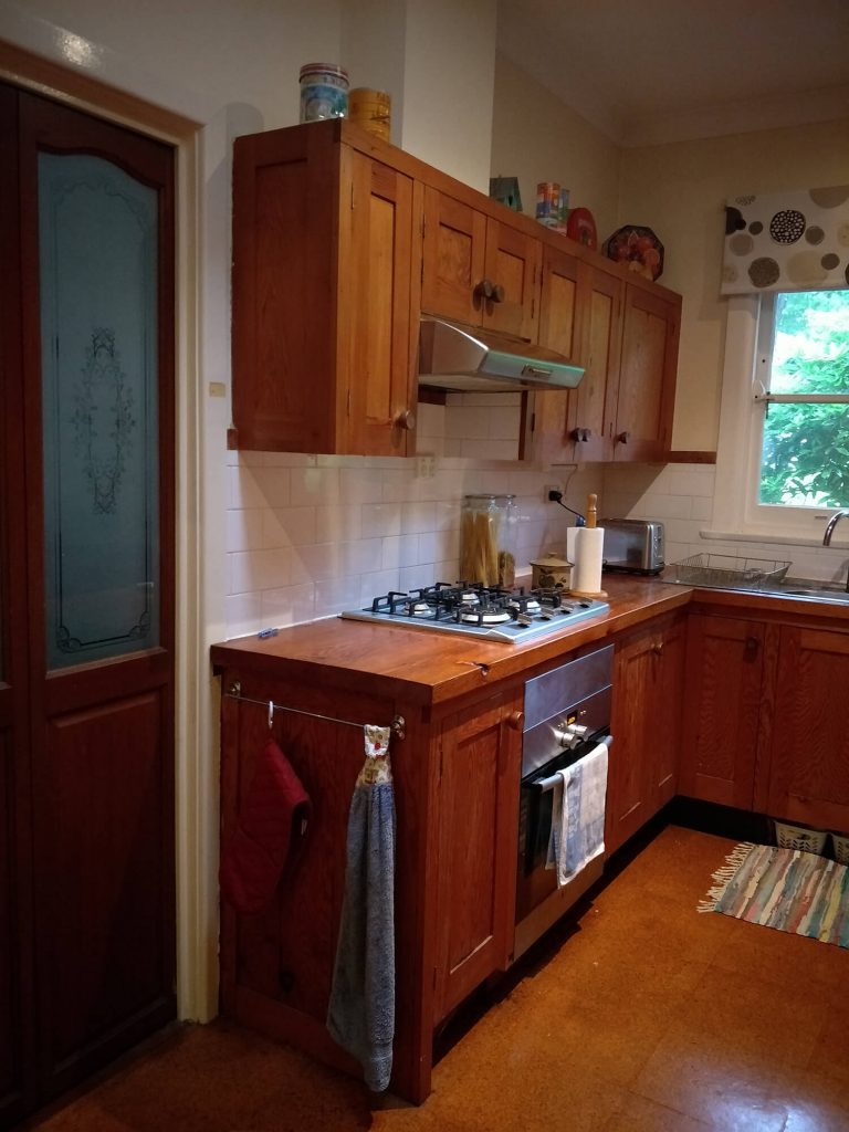 Wooden cabinets and stove top oven in kitchen.