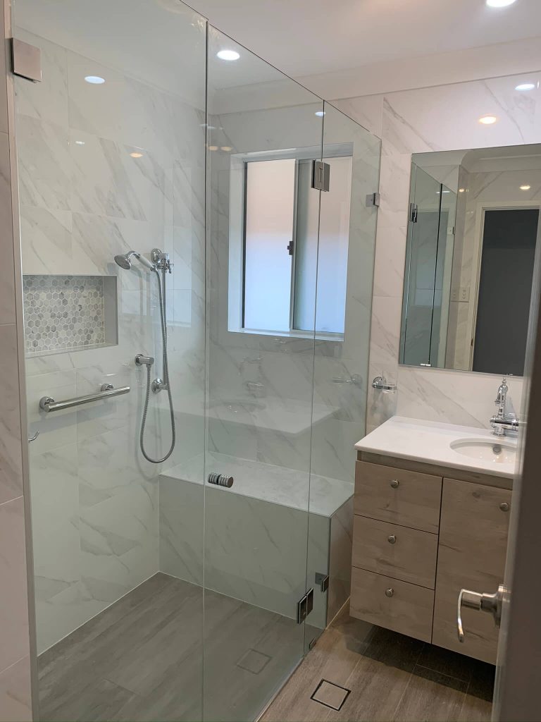 A modern bathroom with a transparent shower door and a sleek sink.